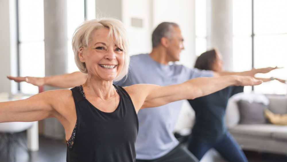 Smiling older lady in exercise class