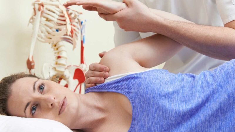 Osteopath treating ladies shoulder